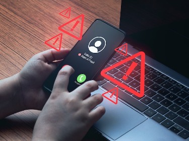 Laptop with scam or fraud triangle with exclamation point alert